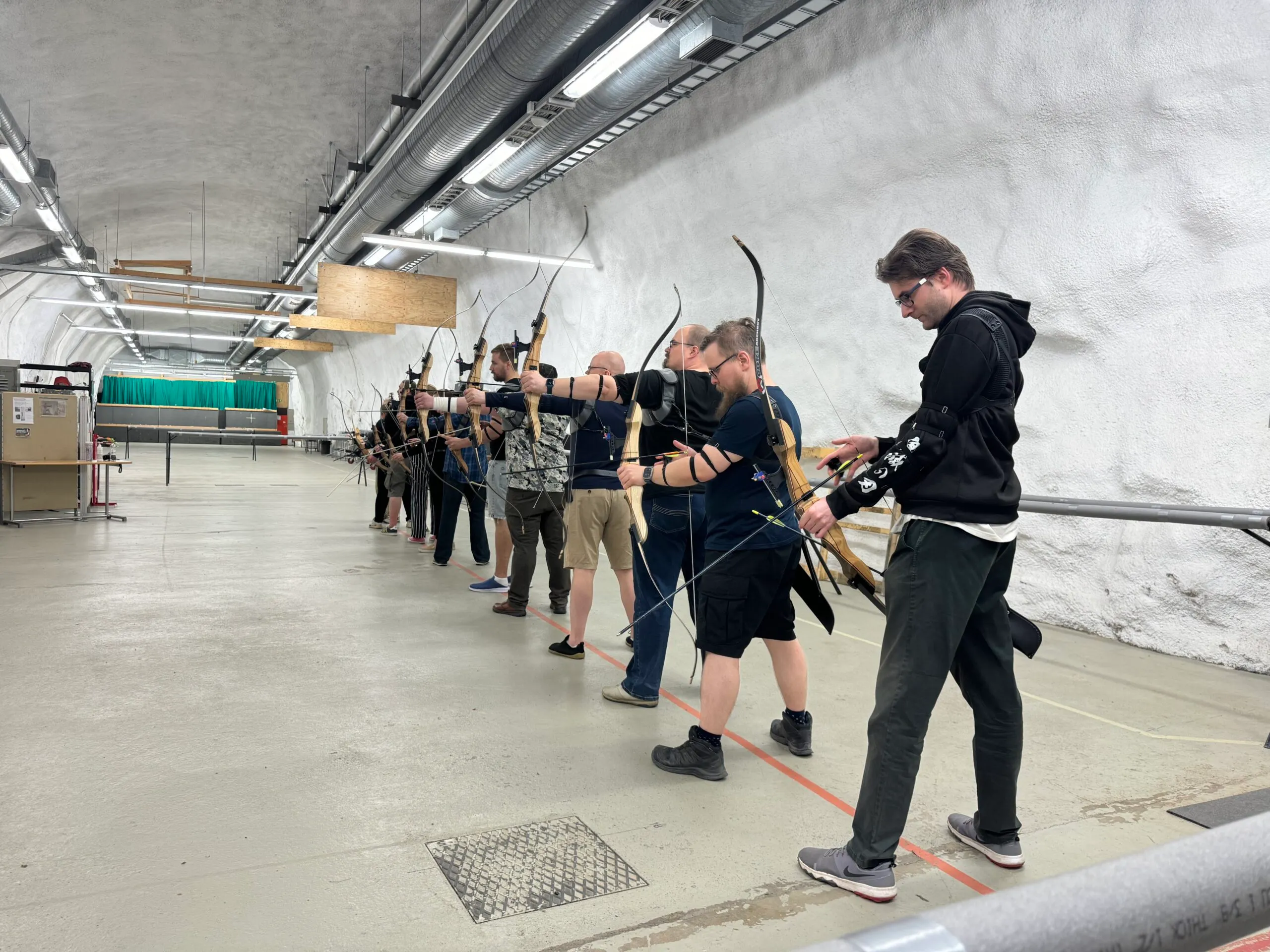 Koudilainen tähtää recurve-jousella Tampereen Jousiampujien sisäradalla.